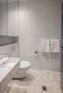 a bathroom with a toilet and a sink and a mirror at Eggies Nest - Sydney City Apartment in Sydney