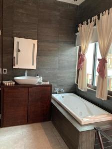 a bathroom with a bath tub and a sink at Hotel Diosa del Agua Bacalar in Bacalar