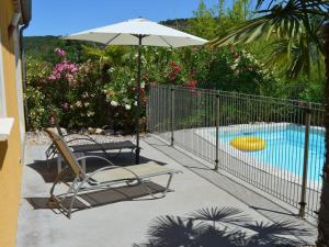 une terrasse avec une chaise, un parasol et une piscine dans l'établissement Comfortable villa with private swimming pool and close to the Ard che River, à Auriolles