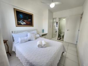 - une chambre avec un lit blanc et des serviettes dans l'établissement AP Alecrim Porto Real Suítes com Tela de Proteção Praia Privativa, à Mangaratiba