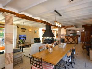 una cucina e un soggiorno con tavolo in legno di Charming holiday home with pool a Lavercantière