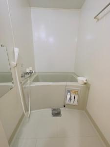 La salle de bains blanche est pourvue d'une baignoire et d'un lavabo. dans l'établissement 6-2新規OPEN　札幌駅から徒歩7分の良い場所！サービスアパートメントSAPPOROステーション6-2　ネット無料, à Sapporo
