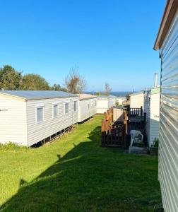a row of white mobile homes in a yard at Trimingham Static Van in Trimingham