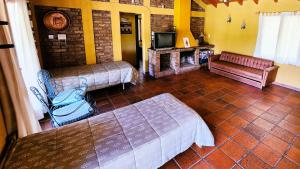 a room with a bed and a fireplace and a tv at Casa Quinta Rodeada de Bodegas Piscina BBQ Mendoza in Maipú