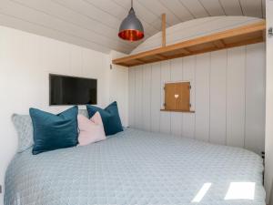 a bedroom with a bed with blue and pink pillows at Little Hut in Weston-super-Mare