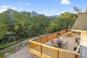 a wooden deck with a table and chairs on it at Secluded Mountain Top Home Minutes to Sequoias & Kings Canyon in Three Rivers