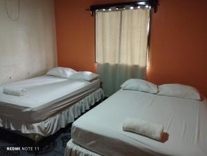 2 camas individuais num quarto com uma janela em Hotel Little Queen Lobster em Laguna de Perlas