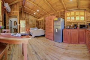 a kitchen and living room of a log cabin at Sámara Tarantela Houses, Casa Sandal in Sámara