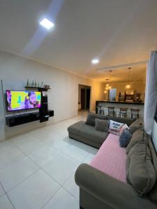 uma sala de estar com um sofá e uma televisão de ecrã plano em casa para alugar em Prado bahia. em Prado