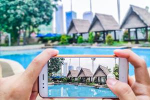 una persona che scatta una foto di una piscina con il suo cellulare di The Ritz-Carlton Jakarta, Mega Kuningan a Giacarta