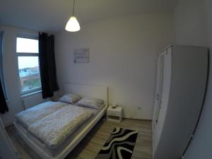 ein kleines Schlafzimmer mit einem Bett und einem Fenster in der Unterkunft Clean & Central 2 Room Apartment 50m² in Hannover