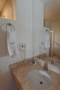 a bathroom with a sink and a white hand towel at Hoteles Unico Express in León