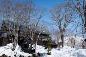 a house in the snow with trees at Niseko HyKrots IKIGAI Village in Niseko