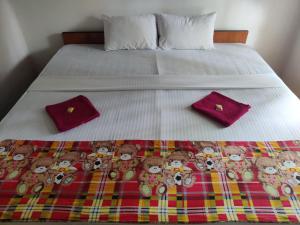 a bed with a group of stuffed teddy bears on it at Catch The Ella Train Hostel in Kandy