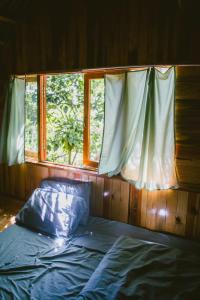 uma cama num quarto com uma janela em Đà Lạt Củi Homestay em Da Lat