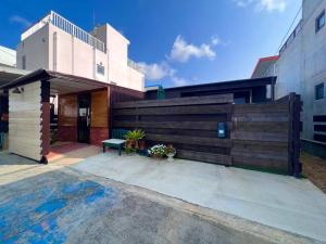una casa con una valla de madera y un banco en とぅも～る, en Ishigaki Island