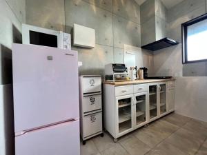 a kitchen with white appliances and a refrigerator at とぅも～る in Ishigaki Island