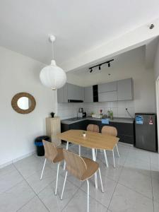 uma cozinha com mesa e cadeiras num quarto em The Sun 1 or 3BR Bayan Lepas 4 to 10 pax em Bayan Lepas