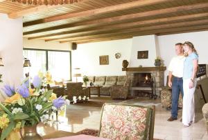 two people standing in a living room with a fireplace at Vital-Hotel Erika in Bad Kissingen