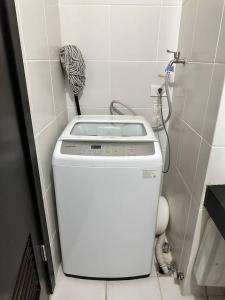 a washing machine in a bathroom next to a toilet at Kasara relaxing abode in Manila