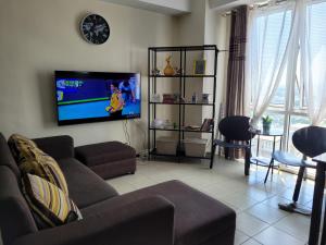 a living room with a couch and a flat screen tv at Kasara relaxing abode in Manila