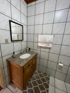 ein Bad mit einem Waschbecken und einem Spiegel in der Unterkunft Casa Benedet's in Lauro Müller