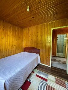 ein Schlafzimmer mit einem Bett in einem Holzzimmer in der Unterkunft Casa Benedet's in Lauro Müller