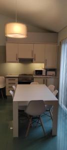uma cozinha com uma mesa branca e cadeiras em Ponta Delgada Apartment T3 em Ponta Delgada