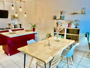 cocina con mesa de madera y sillas azules en Le tout à pied!, en Ciboure