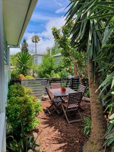 a patio with a table and chairs in a yard at Alice House in Auckland