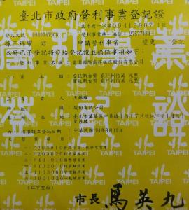 a poster with chinese writing on a yellow wall at Rich Garden Hotel in Taipei