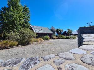 a gravel driveway with rocks and a house at Riverview Lodge in Hanmer Springs