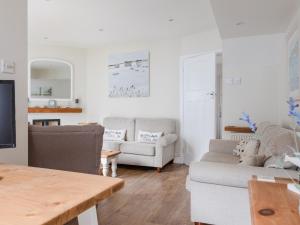 a living room with two couches and a table at 1 Top View Cottages in Salcombe