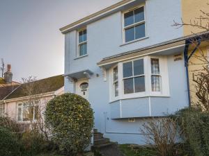 a blue house with a window and bushes at 1 Top View Cottages in Salcombe