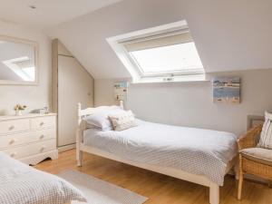 a bedroom with two beds and a window at 1 Top View Cottages in Salcombe