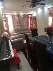 a living room with a piano and a table with a couch at Family Friendly Appartement-Giza in Cairo