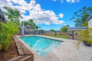 a swimming pool in the yard of a home at Pet Friendly Family Home with Pool Close to Theme Parks in Gold Coast