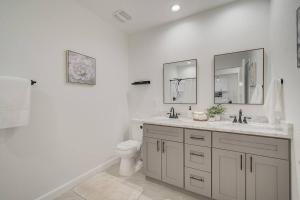 a white bathroom with a toilet and two mirrors at Beautiful family vacation house in Rotonda West +43 photos