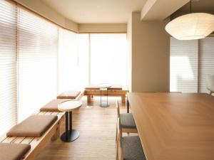 a conference room with benches and tables and a large window at Vessel Inn Asakusa Tsukuba Express in Tokyo