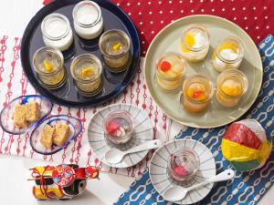 a table with two plates of food and jars of jam at Vessel Inn Asakusa Tsukuba Express in Tokyo