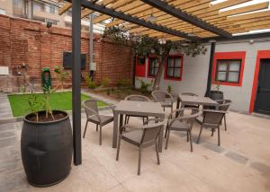 un patio al aire libre con mesas, sillas y una planta en Casa Recreo, en Viña del Mar