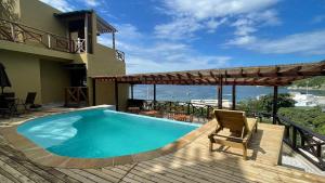 a house with a swimming pool and a chair on a deck at Cabañas Paraiso in Taganga