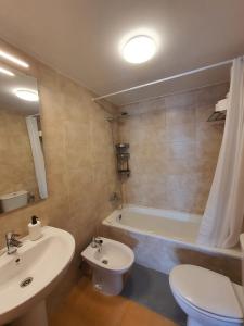een badkamer met een wastafel, een toilet en een bad bij Roseville in Puerto del Rosario