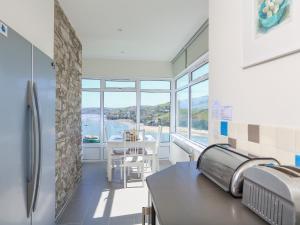 a kitchen with a view of the water and a table at Edinburgh House in Salcombe