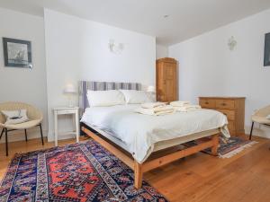 a bedroom with a large bed with a rug at Edinburgh House in Salcombe