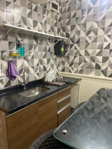 a kitchen with a sink and a tiled wall at Hotel Taguatinga Flat - conforto e requinte - Apto 416 in Brasilia