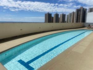 a swimming pool on the roof of a building with tall buildings at Hotel Taguatinga Flat - conforto e requinte - Apto 416 in Brasilia