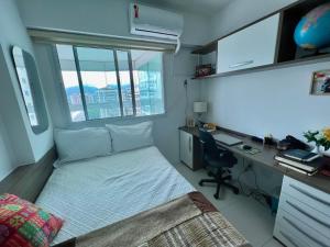 um quarto com uma cama e uma secretária com um computador em Barra da Tijuca Depto decorado en Exclusivo Resort no Rio de Janeiro