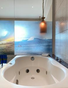 uma banheira na casa de banho com um quadro em Pousada Ubuntu em Ubatuba