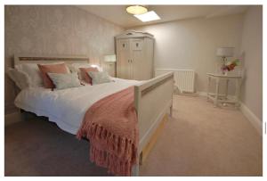 een slaapkamer met een groot bed met witte lakens en kussens bij Church Farm Bed and Breakfast 